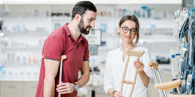 Woman helping man select crutches